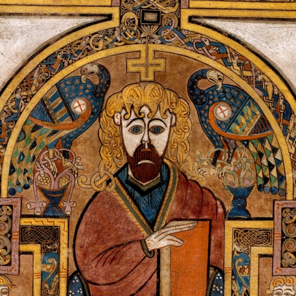 Two peacocks sit on either side of Jesus in an illustration from the Book of Kells