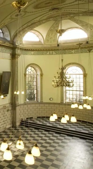 downwards facing view of chandeliers in trinity college exam hall