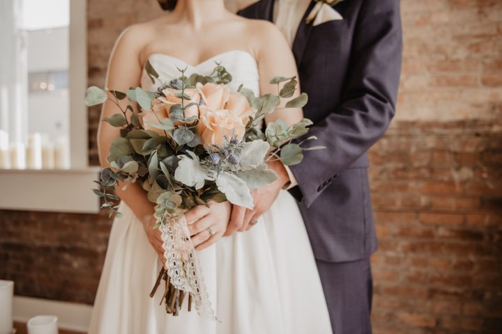 bride and groom standing with flowers