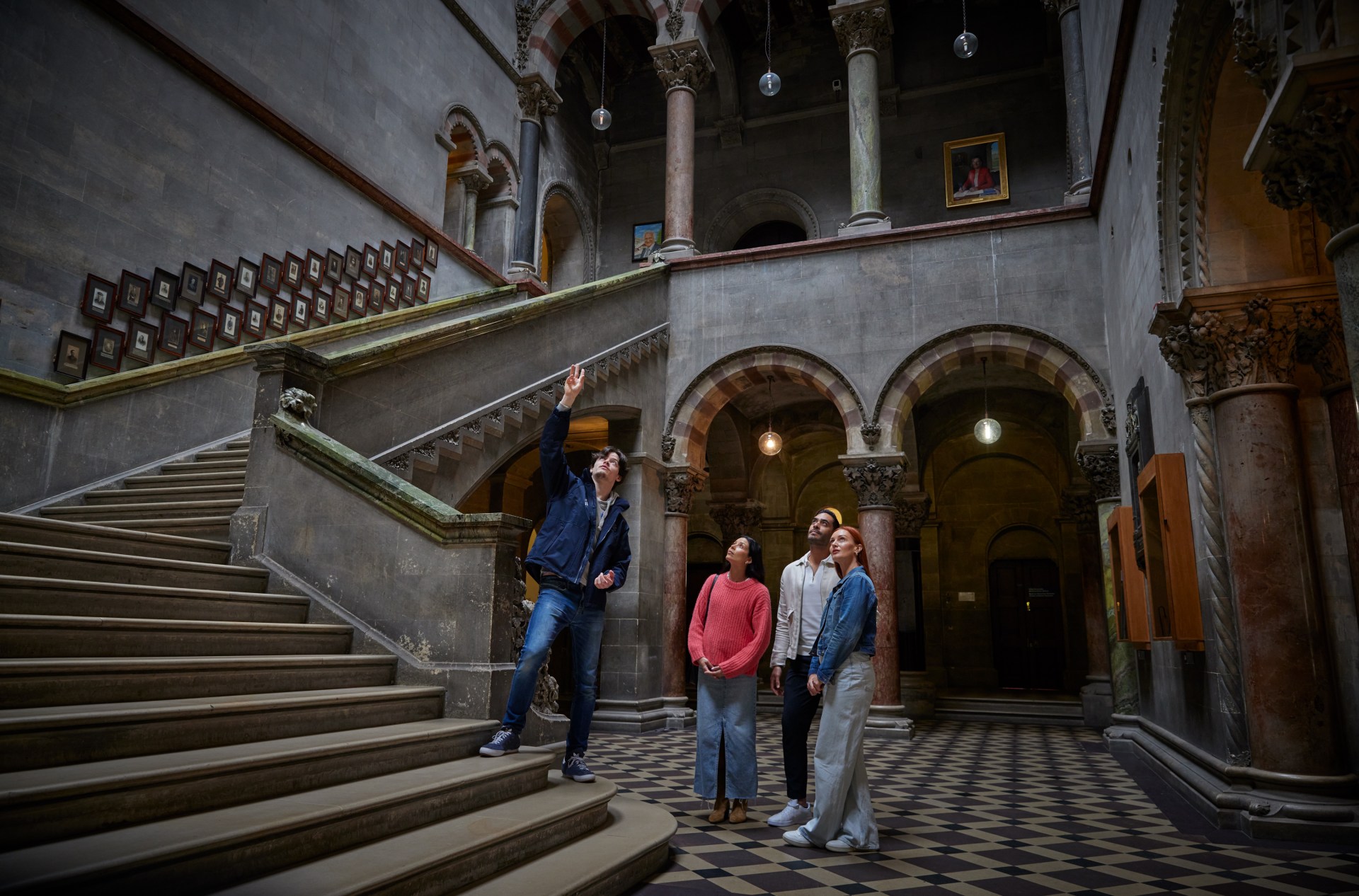 A tour guide with 3 people in Trinity's Museum Building.