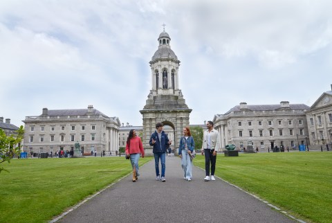 A tour guide walks through Trinity with a group of 3 people