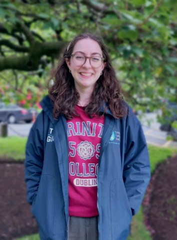 Tour guide smiling on front of a tree at Trinity