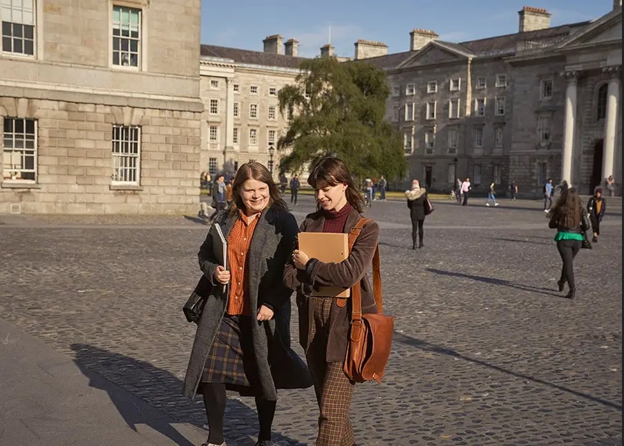 Two actors from Normal People walking through Trinity's Front Square