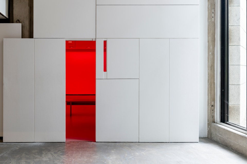 A door half open revealing a red room