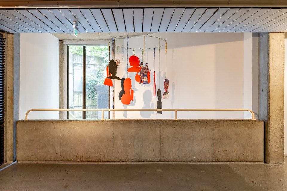 Hanging colourful sculptures in the Douglas Hyde Gallery with a plain concrete wall