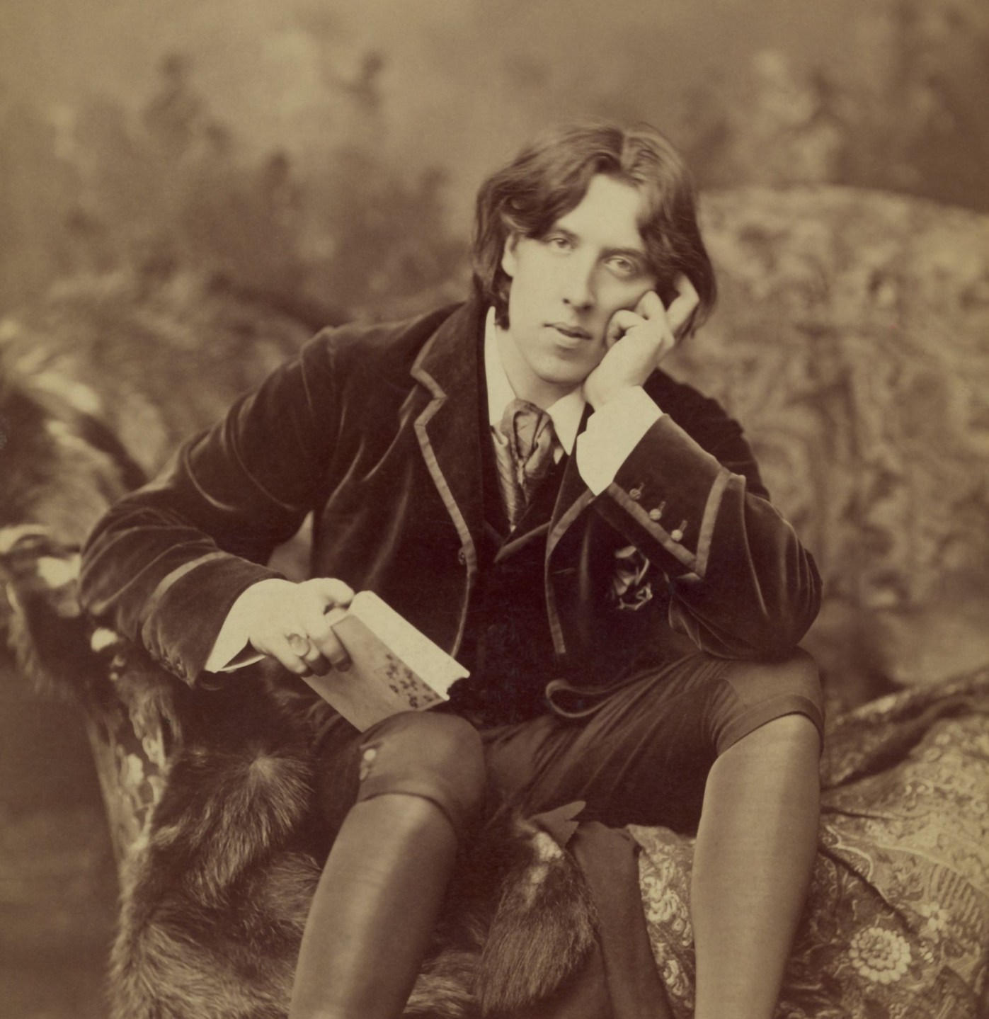 A black and white photo of Oscar Wilde, seated