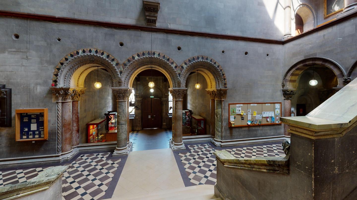 Stone arches marble banister and chequered floor in the Museum Building