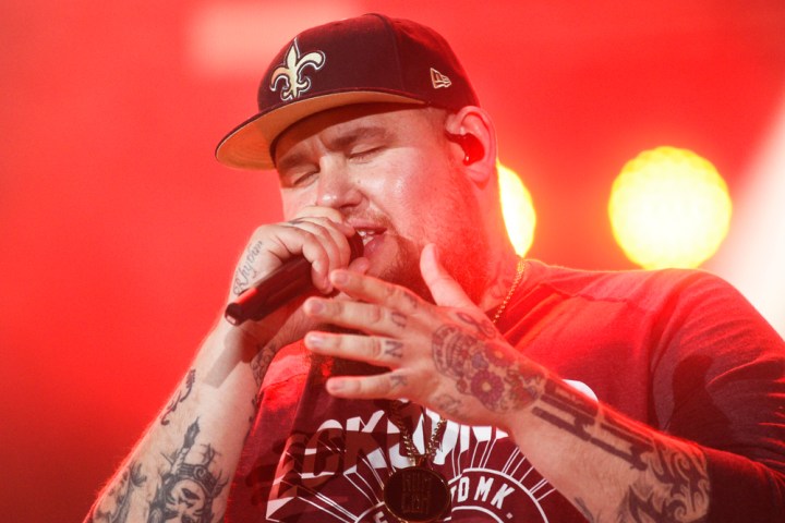 Rag n Bone Man on stage with a microphone and red lighting