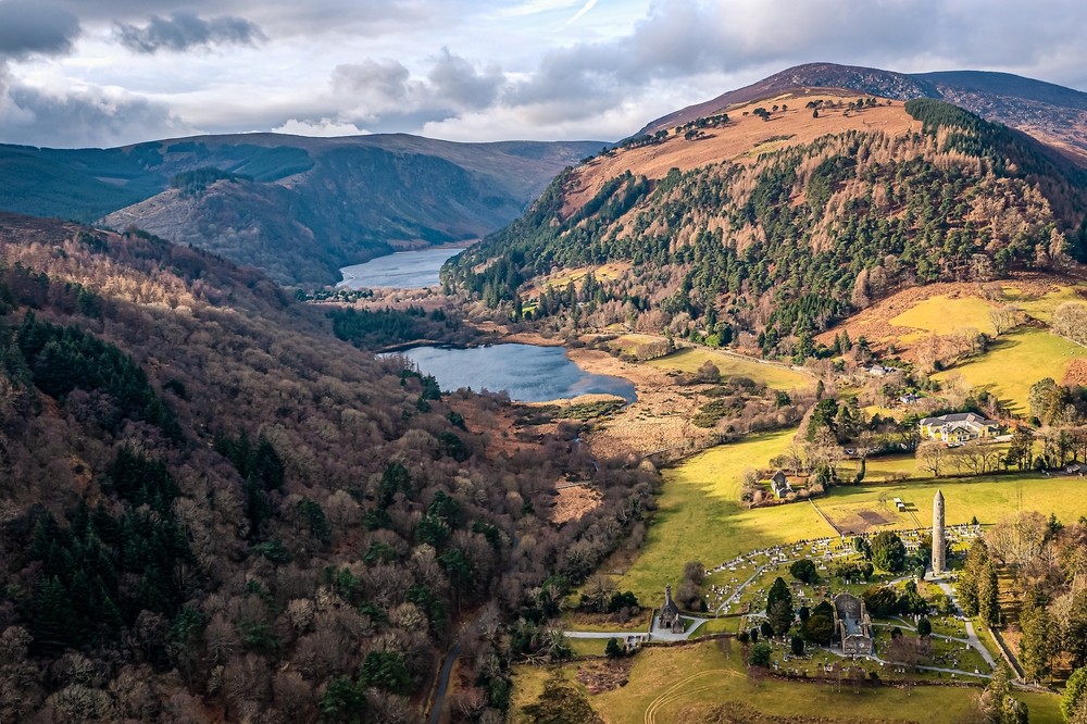 Sunlight moves over a valley with stone monuments and lakes