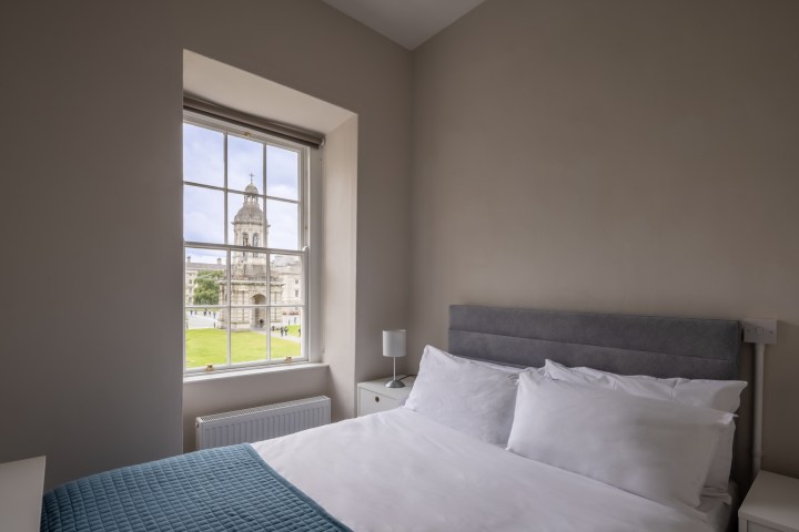 Double bed with a view of the bell tower structure in Trinity Front Square